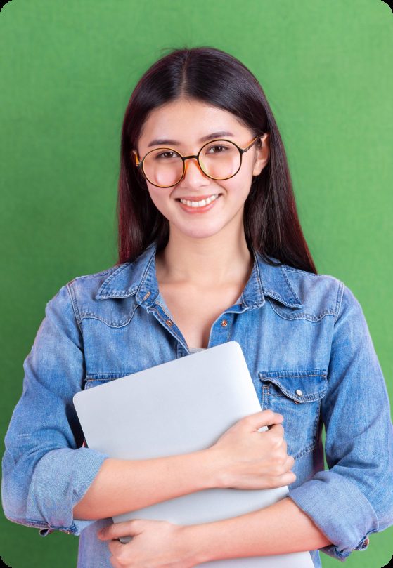 Student smiling while holding a laptop