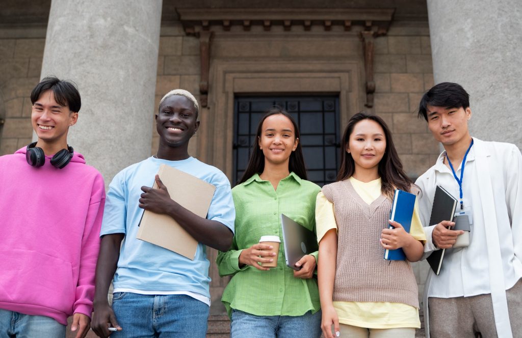 Prospective students with their notebooks outside a university building